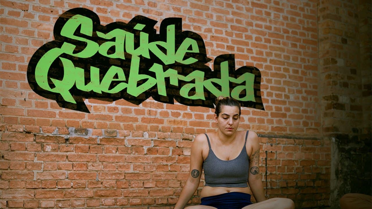Mulher sentada diante de uma parede de tijolos com o logo Saúde Quebrada pintado em grafite verde